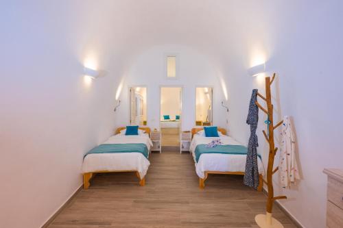 a room with two beds and a mirror at Vivid Caves 2 Bedroom Cavehouse in Foinikiá