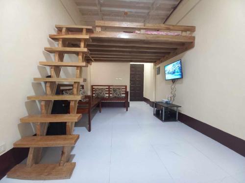 a room with a wooden spiral staircase and a tv at Condo for Rent - Cagayan de Oro in Cagayan de Oro