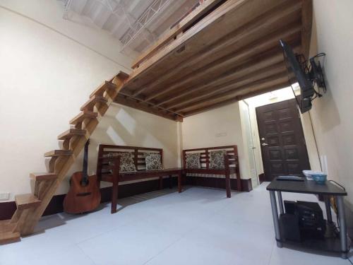 a room with a staircase with a guitar and a table at Condo for Rent - Cagayan de Oro in Cagayan de Oro