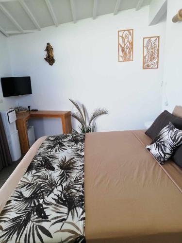 a bedroom with a bed with a black and white blanket at EDEN Private Pool Suites and Panoramic Agung View - ADULT ONLY in Nusa Penida