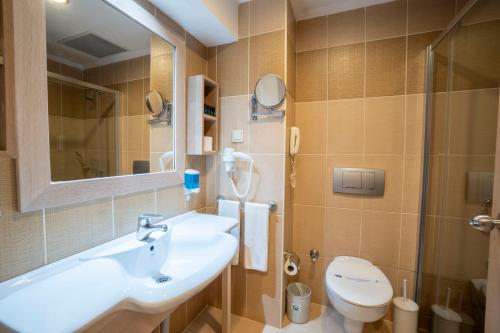La salle de bains est pourvue d'un lavabo, de toilettes et d'un miroir. dans l'établissement Side Breeze Hotel, à Antalya
