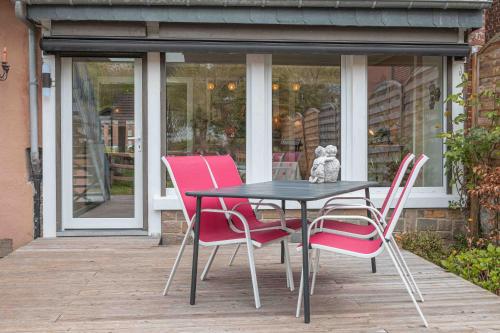 a table and four pink chairs on a patio at Les Gites Kangourou Dinant in Dinant
