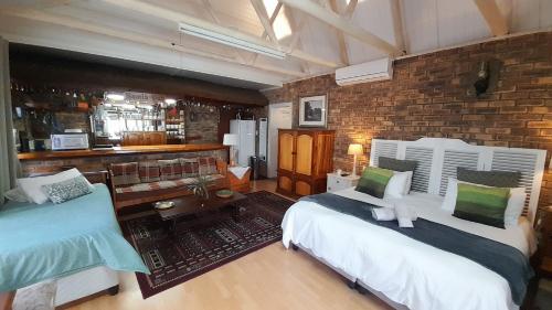 a bedroom with two beds and a brick wall at Vergenoegd in Panorama