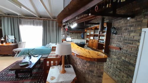 a living room with a table and a brick wall at Vergenoegd in Panorama