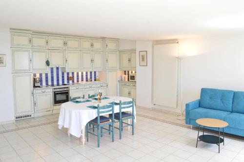 une cuisine avec une table, des chaises et un canapé bleu dans l'établissement Appartement vue mer proches plages et congrès, à Cannes