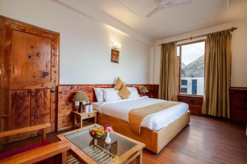 um quarto de hotel com uma cama e uma janela em JJ By Vivaan Resort em Shamshi