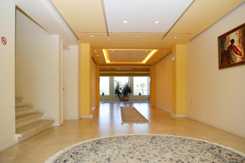 a hallway with yellow walls and a rug at Grand White City Hotel in Berat