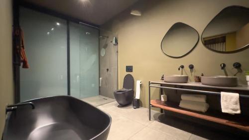 a bathroom with a tub and two sinks and a toilet at Overstory Forest Cabins Ironwood in Cape Town