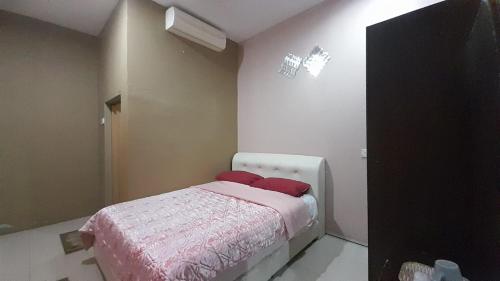 UMMUL MOTEL في أروا: غرفة نوم عليها سرير ومخدات حمراء
