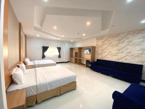 芹苴的住宿－MIỀN TÂY HOTEL CANTHO，一间大卧室,配有两张床和一张蓝色的沙发