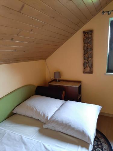 a bed in a room with a wooden ceiling at Morycówka in Rzyki