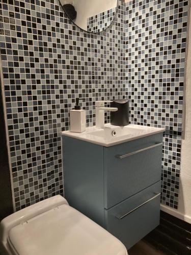 une salle de bain avec un lavabo bleu et des toilettes dans l'établissement Studio à La Rochelle, à La Rochelle