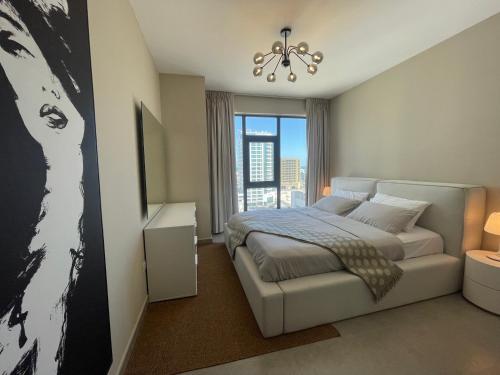 a bedroom with a large bed and a chandelier at 2 Luxury bedroom Apartment In Amwaj Island in Qalānī