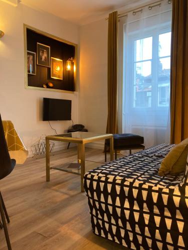 une chambre avec un lit, une table et une fenêtre dans l'établissement Studio à La Rochelle, à La Rochelle