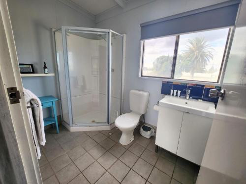 y baño con ducha, aseo y lavamanos. en Sands Beach House, en Jurien Bay