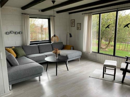 uma sala de estar com um sofá e uma mesa em Cozy Cottage Close To The Beach, em Bogense