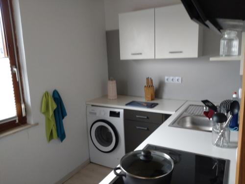 a kitchen with a washing machine and a sink at Gästezimmer M. Schubert in Oberelbert