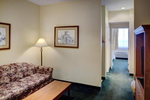 a hotel room with a couch and a hallway at Lakeview Inns & Suites - Okotoks in Okotoks