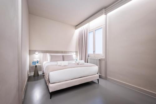 a white bedroom with a large bed and a window at Sweet Inn - Gaudi Avenue in Barcelona