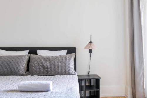 a white bedroom with a bed and a lamp at 3 Bedroom Flat in Lovely Area in Copenhagen