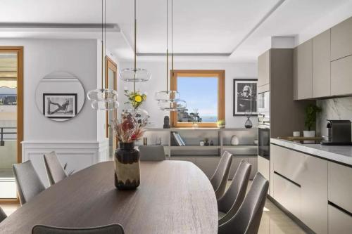 a kitchen with a wooden table with chairs and a vase with flowers at luxurious penthouse of Cannes in Cannes