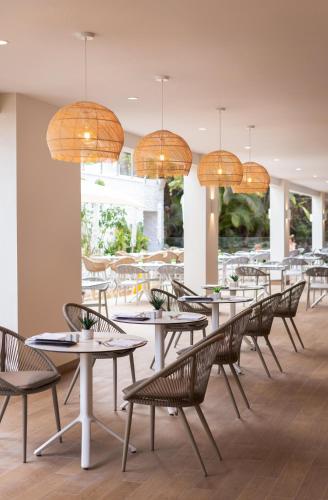 a dining room with tables and chairs and chandeliers at Maspalomas Princess in Maspalomas