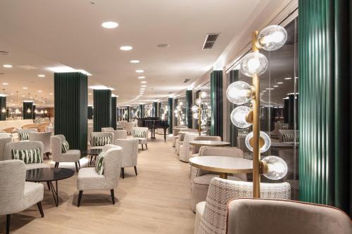 a restaurant with white chairs and tables and lights at Maspalomas Princess in Maspalomas