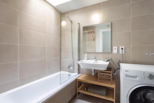 La salle de bains est pourvue d'un lavabo et d'un lave-linge. dans l'établissement Maruxía Beach and Pool apartemnt, à Abades