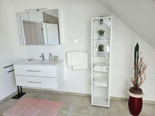 a white bathroom with a sink and a mirror at FeWo Nahner Loft in Osnabrück