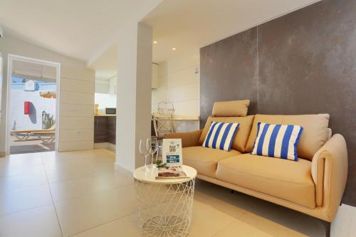a living room with a couch and a table at Neptuno Bungalows - Adults Only in Corralejo
