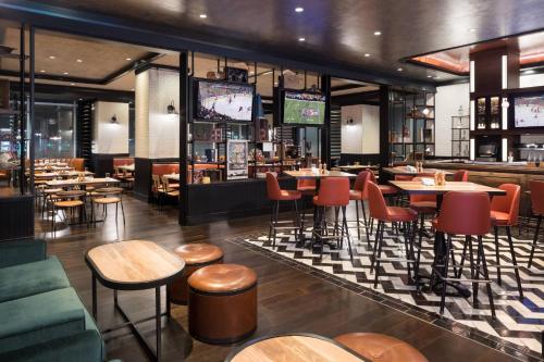 a restaurant with tables and chairs and televisions at JW Marriott Parq Vancouver in Vancouver