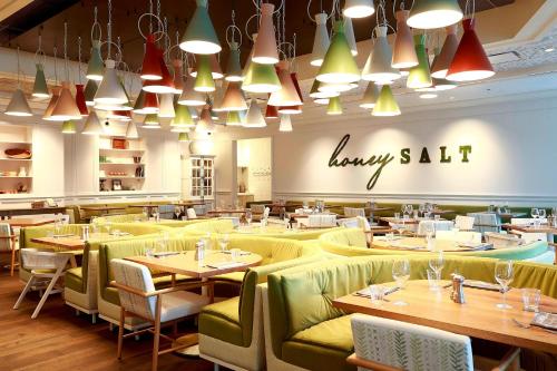a restaurant with tables and green chairs and lights at JW Marriott Parq Vancouver in Vancouver