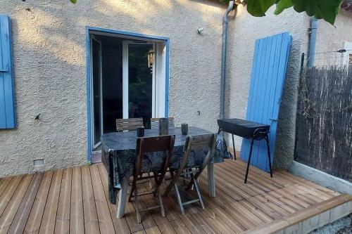 une table et des chaises sur une terrasse en bois dans l'établissement Chez Lucie, à Saint-Maime
