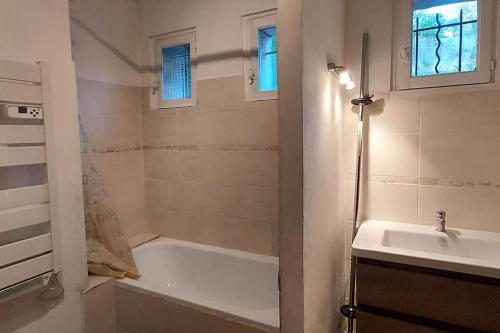 La salle de bains est pourvue d'une baignoire et d'un lavabo. dans l'établissement Chez Lucie, à Saint-Maime