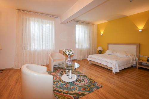 a bedroom with a bed and a table and a couch at Grand White City Hotel in Berat