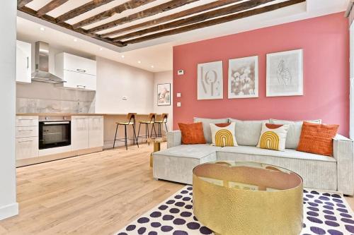 - un salon avec un canapé blanc et un mur rouge dans l'établissement Appartement 3 chambres Paris Sentier, à Paris