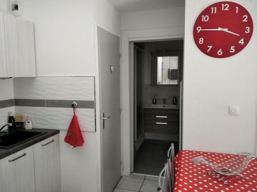 une cuisine avec une horloge accrochée au mur dans l'établissement Soleil de Sète, à Sète