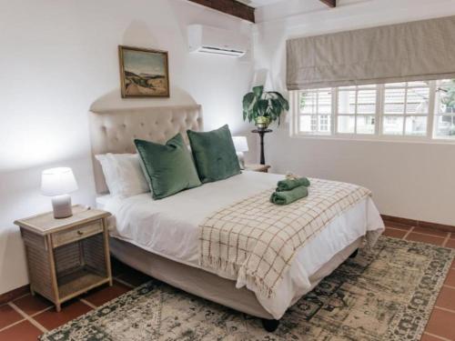 Un dormitorio con una cama con un osito de peluche. en Wylde Rose Cottage en Pietermaritzburg
