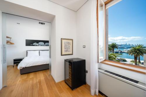 - une chambre avec un lit et une grande fenêtre dans l'établissement Imperial suite, à Split
