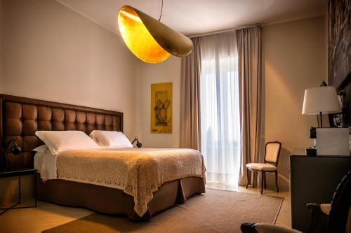 a bedroom with a large bed and a yellow light at Aria Rooms and Terrace in Noto