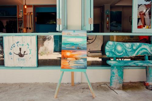 ein Schild vor einem Lagerfenster mit einem Stuhl in der Unterkunft Ocean Pearl Maldives at Gulhi Island in Gulhi