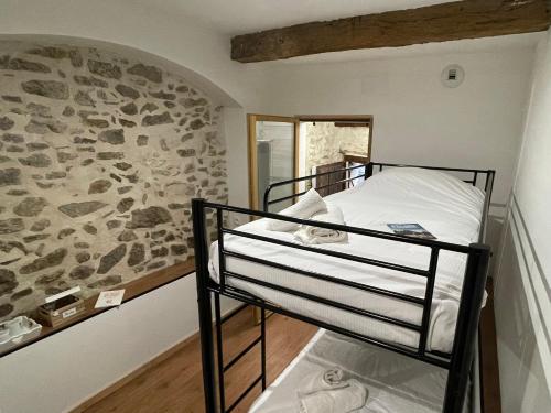 Ce lit superposé se trouve dans un dortoir doté d'un mur en pierre. dans l'établissement Chambre Le 40 marches, à Cucugnan
