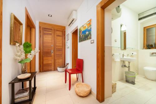 a bathroom with a toilet and a red chair at Imperial suite in Split