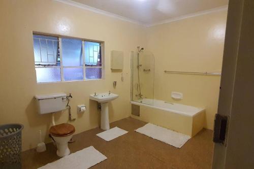 La salle de bains est pourvue d'un lavabo et d'une baignoire. dans l'établissement Garden flat for working person, à Pierre van Ryneveld