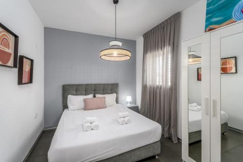 ein Schlafzimmer mit einem Bett mit zwei Handtüchern darauf in der Unterkunft Modern & Sunny 1 BDR w balcony and parking in Tel Aviv