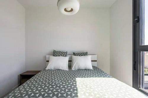 a bedroom with a bed with two pillows at Time suits with beautiful view and pool in Valencia