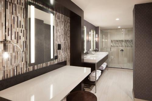 a bathroom with two sinks and a shower at Dallas/Fort Worth Airport Marriott in Irving
