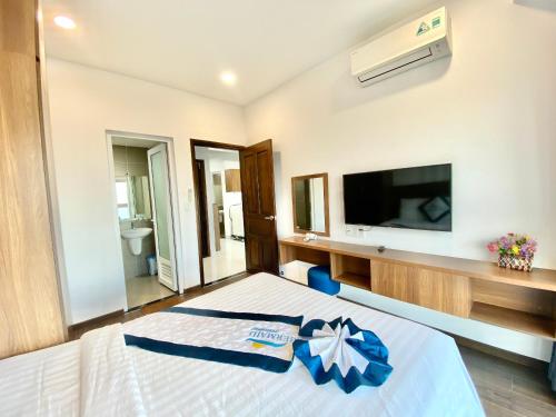 - une chambre avec un lit et une télévision murale dans l'établissement Phu My hotel - Vung Tau Stream home 72, à Phú Mỹ