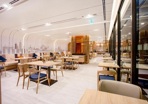 a restaurant with tables and chairs and a cafeteria at Holiday Inn Express & Suites Bangkok Central Pier by IHG in Bangkok