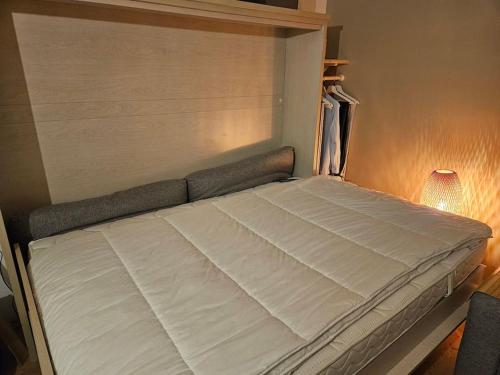 Cette chambre comprend un grand lit blanc et une lampe. dans l'établissement Le plein ciel Studio, à Nice